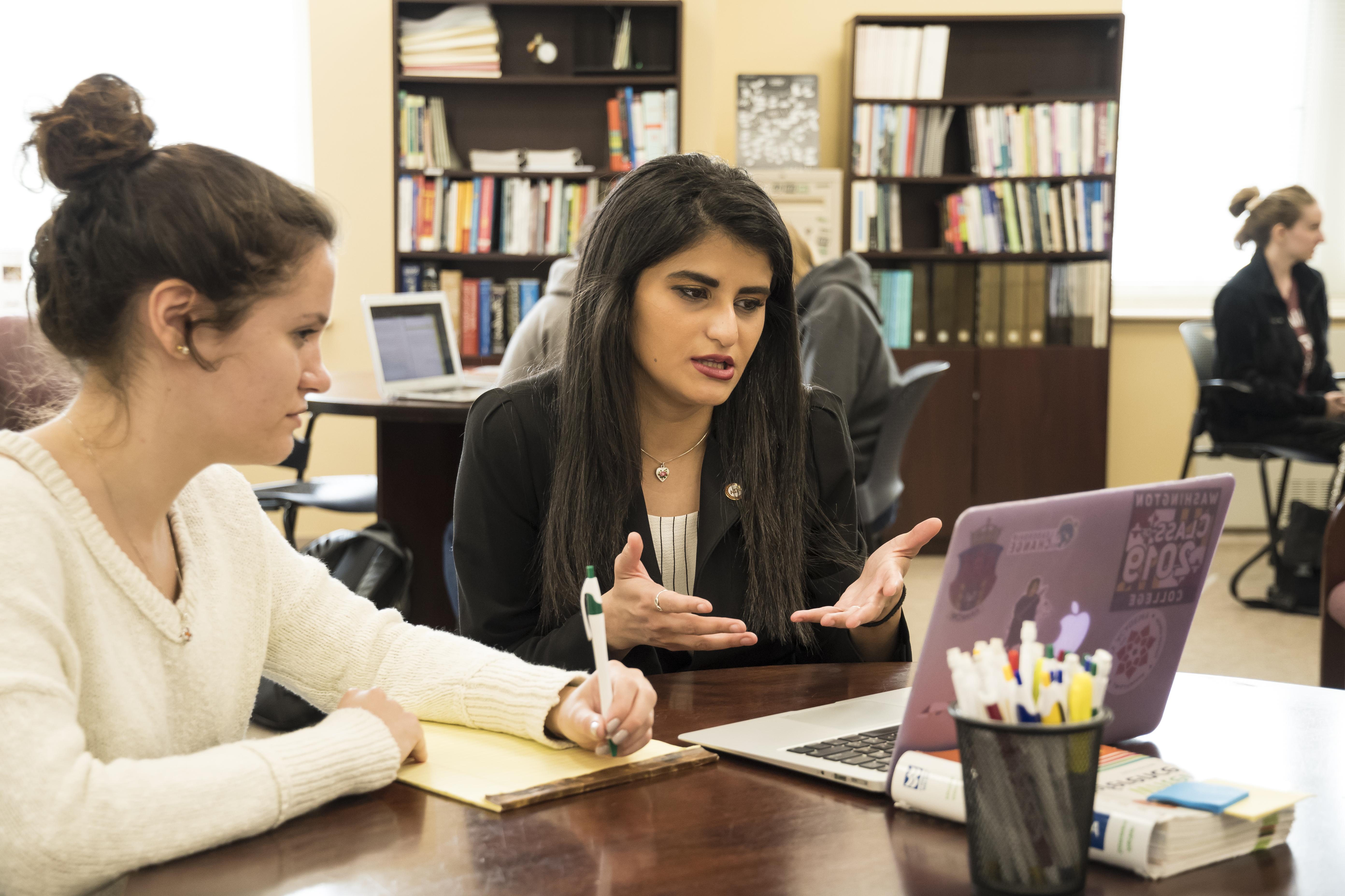 Two Washington College students look at a laptop